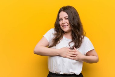 Genç, kıvrımlı, iri yarı bir kadının, avuçlarını göğsüne bastıran dostça bir ifadesi var. Aşk konsepti.