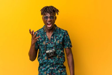 Tatil giymiş genç siyah Rasta adam öfkeyle bağırıyor..