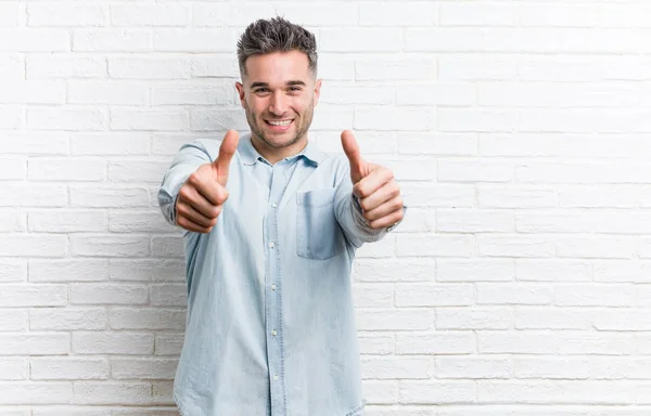 Jonge Knappe Man Tegen Een Muur Met Duimen Omhoog Gejuich — Stockfoto