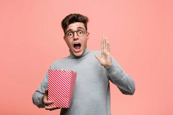 Ung Intellektuell Man Håller Popcorn Hink Glad Leende Och Glad — Stockfoto