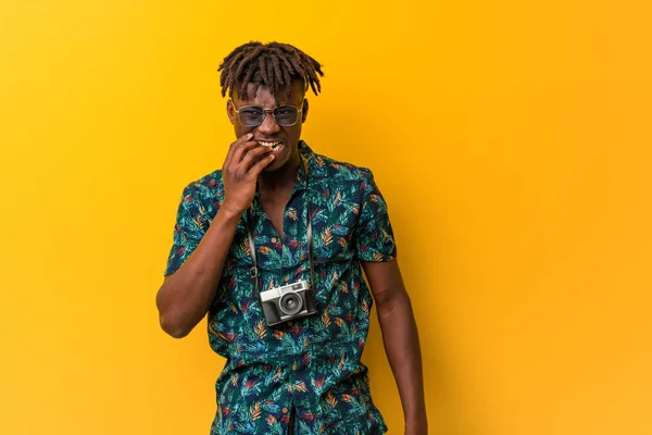 Young black rasta man wearing a vacation look biting fingernails, nervous and very anxious.