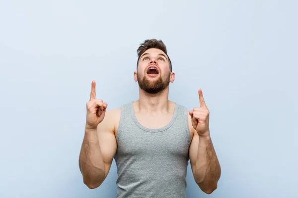 Young Handsome Fitness Man Pointing Upside Opened Mouth — Stock Photo, Image