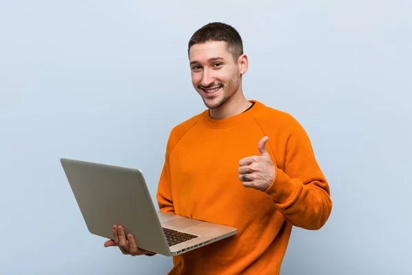 Jovem Caucasiano Segurando Laptop Sorrindo Levantando Polegar — Fotografia de Stock