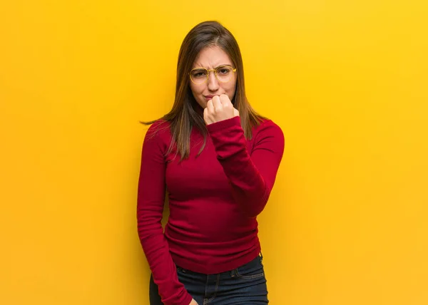 Young intellectual woman showing fist to front, angry expression