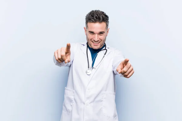 Joven Médico Guapo Hombre Sonrisas Alegres Señalando Hacia Adelante —  Fotos de Stock