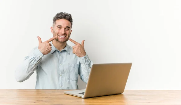 Young Handsome Man Working His Laptop Smiles Pointing Fingers Mouth — Stock Photo, Image