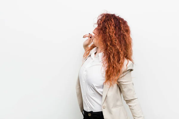 Young natural redhead business woman isolated against white background stretching arms, relaxed position.