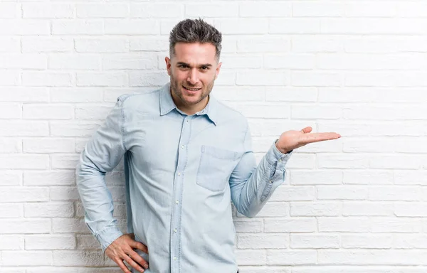 Young Handsome Man Bricks Wall Showing Copy Space Palm Holding — Stock Photo, Image