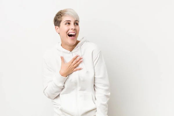 Beyaz Kapüşonlu Genç Kadın Elini Göğsüne Koyduğunda Kahkahalar Atıyor — Stok fotoğraf