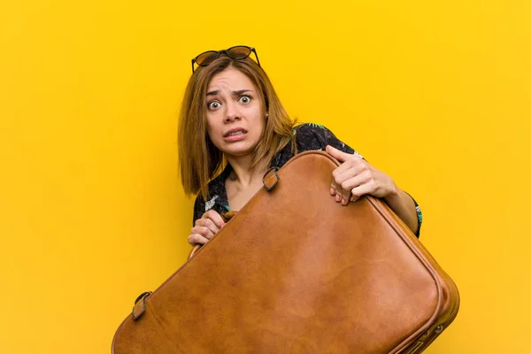 Young woman holding a leather bag  scared about her vacations