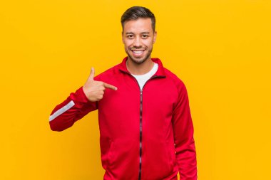 Genç Filipino fitness adamı, tişört fotokopi alanını elle gösteriyor, gururlu ve kendinden emin.
