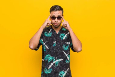 Filipinli genç adam yaz kıyafetleri giyip bir işe odaklanmış, parmaklarını işaret ediyor..