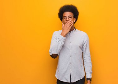 Turuncu bir duvar üzerinde genç afrikalı Amerikalı adam yorgun ve çok uykulu