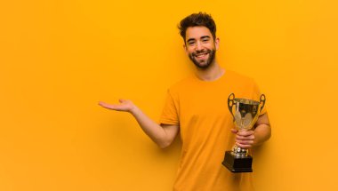 Elinde bir kupa tutan genç adam.