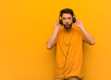 Müzik dinleyen genç adam bir dedikodu dinlemeye çalış.