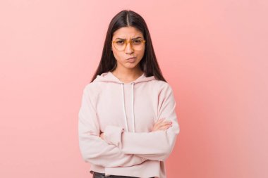 Genç, güzel bir Arap kadın, sıradan bir spor giysisi giymiş, hoşnutsuzca kaşlarını çatmış, kollarını kavuşturmuş..