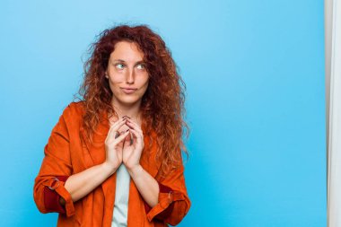 Genç, kızıl saçlı, zarif bir kadın. Kafasında bir plan kuruyor..