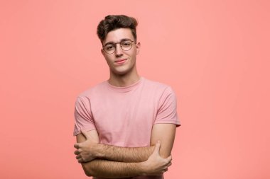 Kendine güveni tam, kararlılıkla kollarını kavuşturan genç, havalı, beyaz bir adam..