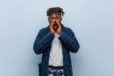 Genç Afrikalı siyah adam pijama giyip heyecanla bağırıyor..