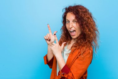 Genç kızıl saçlı zarif bir kadın işaret parmaklarıyla fotokopi alanını işaret ederek heyecan ve arzusunu ifade ediyor..