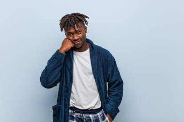 Üzgün ve dalgın hisseden ve fotokopi alanına bakan pijama giyen Afrikalı genç bir adam..