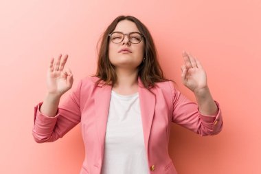 Genç ve cüsseli beyaz kadın sıkı çalışma gününden sonra rahatlıyor, o yoga yapıyor..