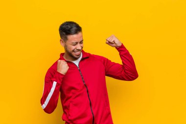 Genç Filipinli fitness adamı zaferden sonra yumruğunu kaldırıyor, kazanan konsept.