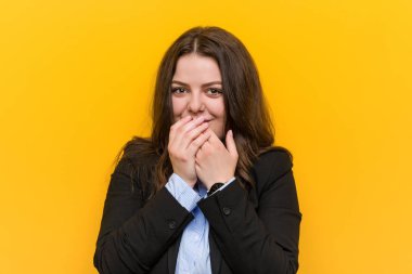 Genç ve beyaz bir iş kadını bir şeye gülüyor, ağızlarını elleriyle kapatıyor..