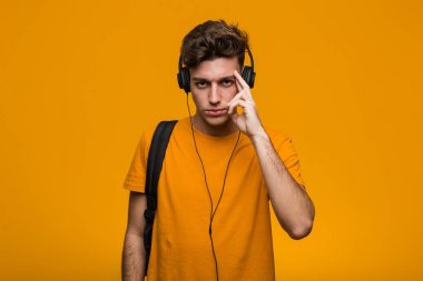 Kulaklıkla müzik dinleyen genç havalı bir öğrenci bir dedikoduyu dinlemeye çalışıyor..