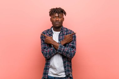 Genç Afrikalı siyah adam yan noktaları, iki seçenek arasında seçim yapmaya çalışıyor.