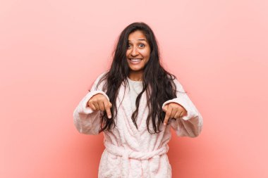 Genç Hintli kadın pijama noktalarını parmaklarıyla aşağı indiriyor, olumlu bir his..