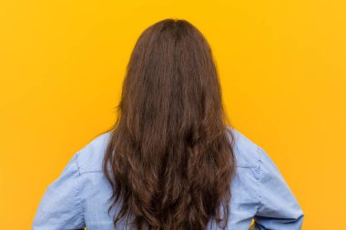 Genç, kıvrımlı, uzun boylu bir kadın, geriye bakıyor..