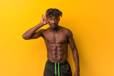 Genç siyah adam mayo giyip dedikodu dinliyor..