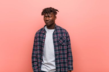 Genç Afrikalı siyahi adam şaşkın, şüpheli ve güvensiz hissediyor..