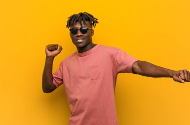 Gündelik siyah adam güneş gözlüğü takıp dans ediyor ve eğleniyor..