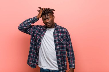 Genç Afrikalı siyahi adam yorgun ve uykulu ellerini başının üstünde tutuyor..