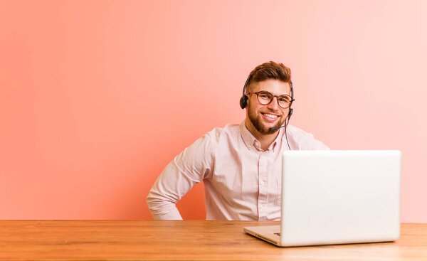 Young man working in a call center confident keeping hands on him hips.