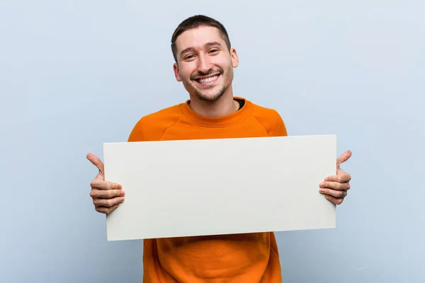 Νεαρός Καυκάσιος Που Κρατάει Πλακάτ Χαμογελώντας Και Ανασηκώνοντας Τον Αντίχειρα — Φωτογραφία Αρχείου