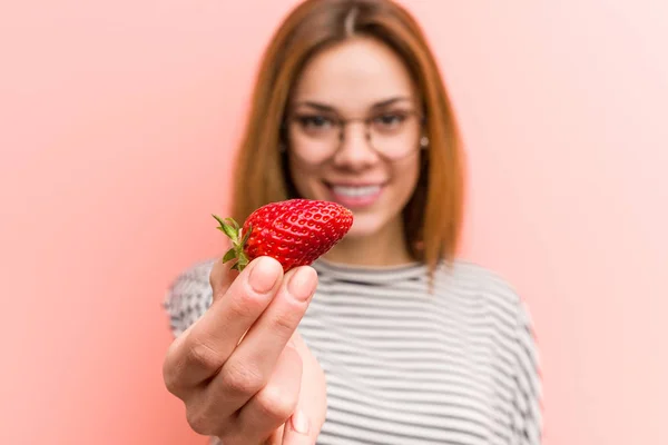 Retrato de mujer joven degustando una fresa fresca —  Fotos de Stock