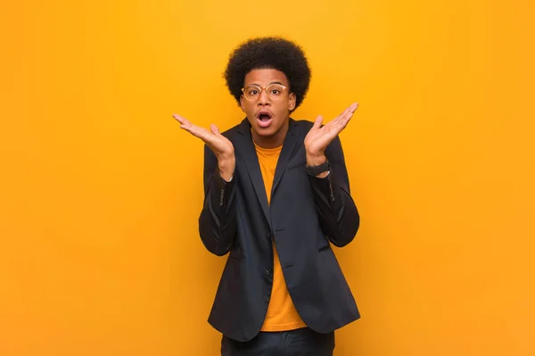 Jovem Empresário Afro Americano Homem Sobre Uma Parede Laranja Surpreso — Fotografia de Stock