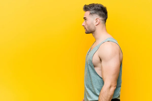 Homem Fitness Jovem Contra Fundo Amarelo Olhando Para Esquerda Pose — Fotografia de Stock