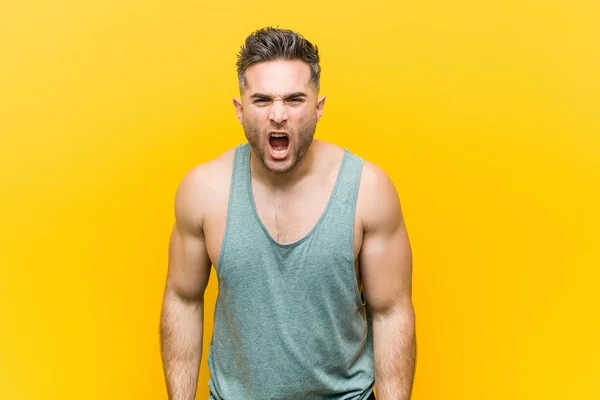 Jonge Fitness Man Tegen Een Gele Achtergrond Schreeuwen Zeer Boos — Stockfoto