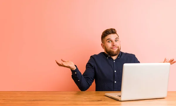 Joven Trabajando Con Portátil Dudando Encogiéndose Hombros Gesto Interrogación —  Fotos de Stock