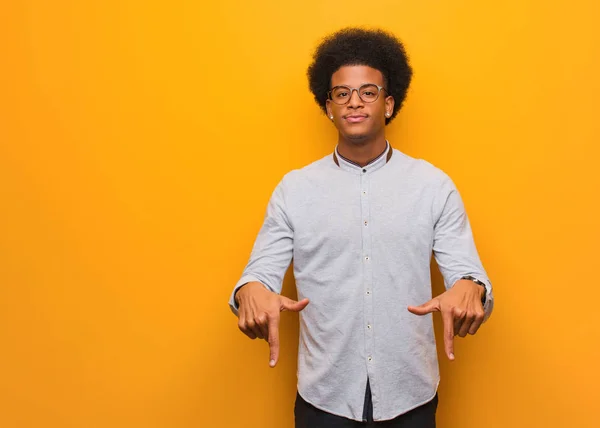 Jovem Afro Americano Sobre Uma Parede Laranja Apontando Para Fundo — Fotografia de Stock