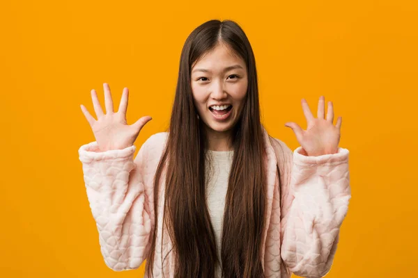 Młoda Chinka Piżamie Pokazuje Dziesiątkę Rękami — Zdjęcie stockowe