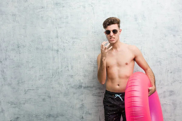 Young Man Holding Pink Inflatable Donut Wearing Swimsuit Upset Screaming — Stock Photo, Image