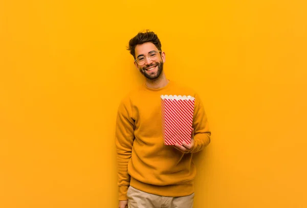 Giovane Uomo Che Tiene Popcorn Incrociando Braccia Sorridente Rilassato — Foto Stock