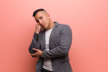 Genç zarif Latin bir adam bir şeyler düşünüyor, yan tarafa bakıyor.