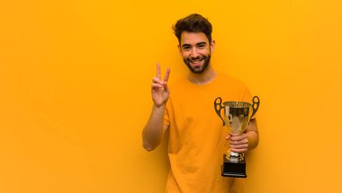 Genç adam elinde iki numaralı kupayı tutuyor.