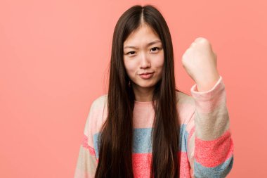 Kameraya yumruğunu gösteren genç havalı Çinli kadın, agresif yüz ifadesi..